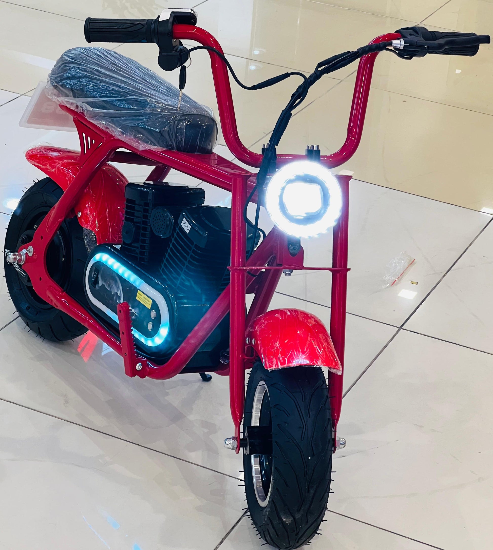 Kid cruising on a mini electric bike with safety gear outdoors.